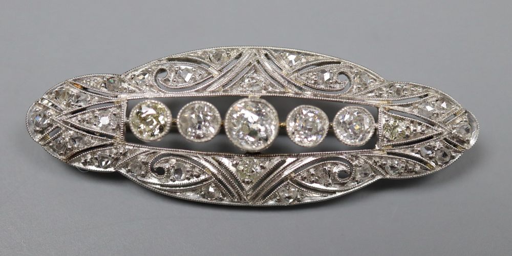 A 1920s pierced white metal and diamond set shaped oval brooch, 42mm, gross 5.8 grams.